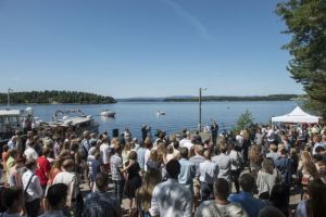 crowds gather by the shore to remember
